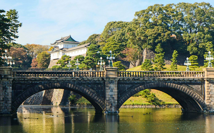 Bridge overlooking Tokyo Imperial Palace with surrounding trees and water.