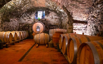 Wine barrels in a rustic cellar in Chianti, Tuscany, part of the semi-private grand tour.