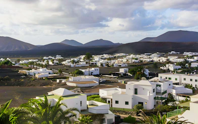 Small town near Timanfaya National Park with white buildings and volcanic landscape.