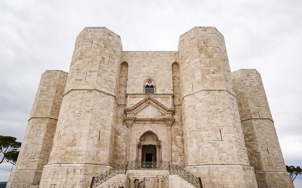 Castel del Monte's octagonal towers under a cloudy sky, Italy.