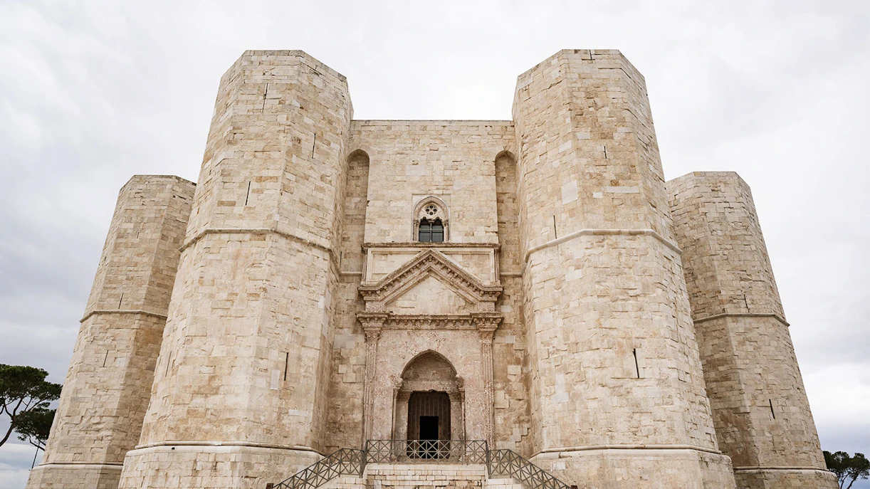 Castel del Monte's octagonal towers under a cloudy sky, Italy.