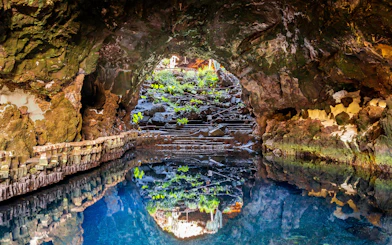 Cave Jameos del Agua with volcanic rock formations and reflective pool, Lanzarote, Canary Islands.