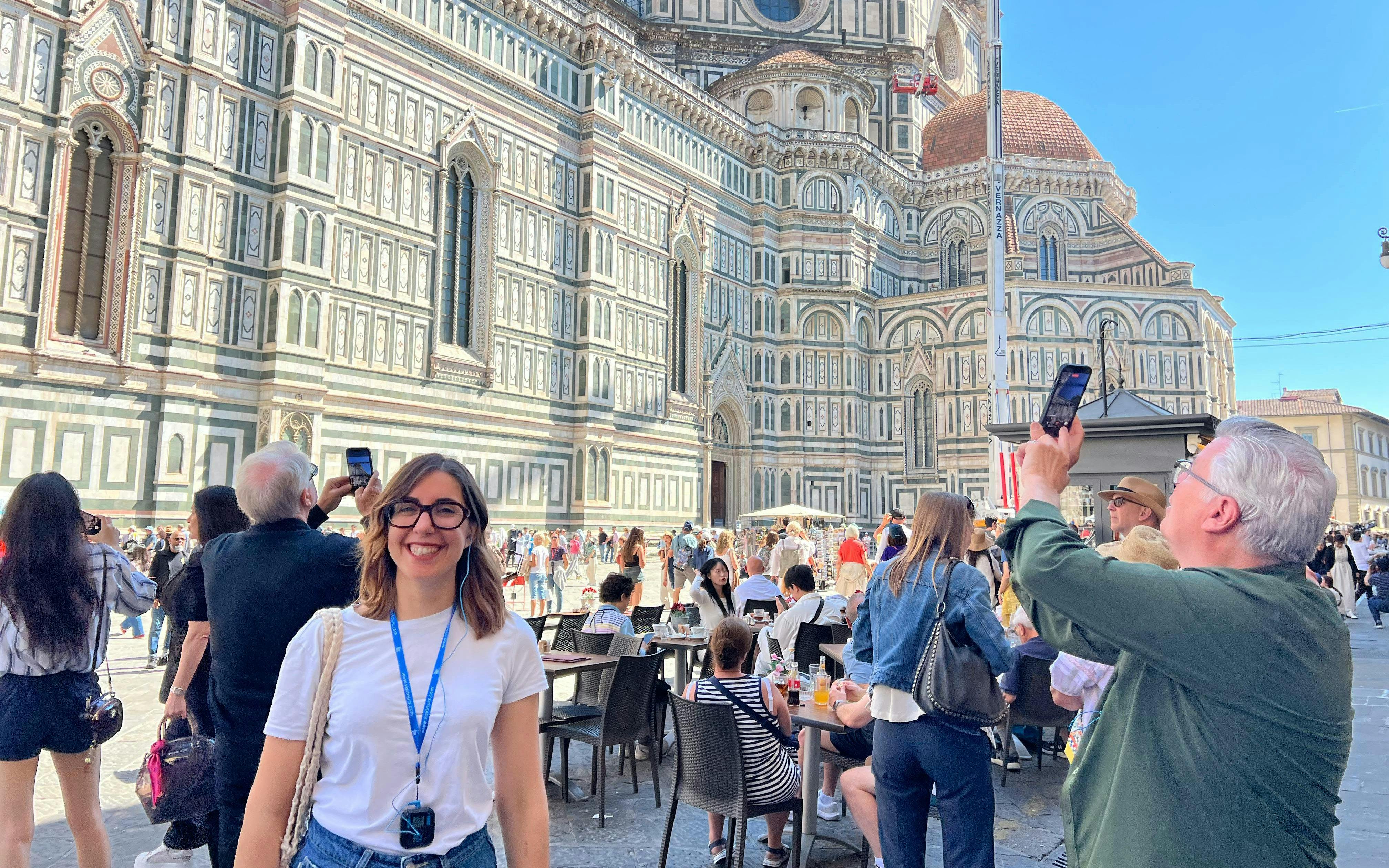 Tourists outside Florence Cathedral, Italy, capturing photos and enjoying the historic architecture.