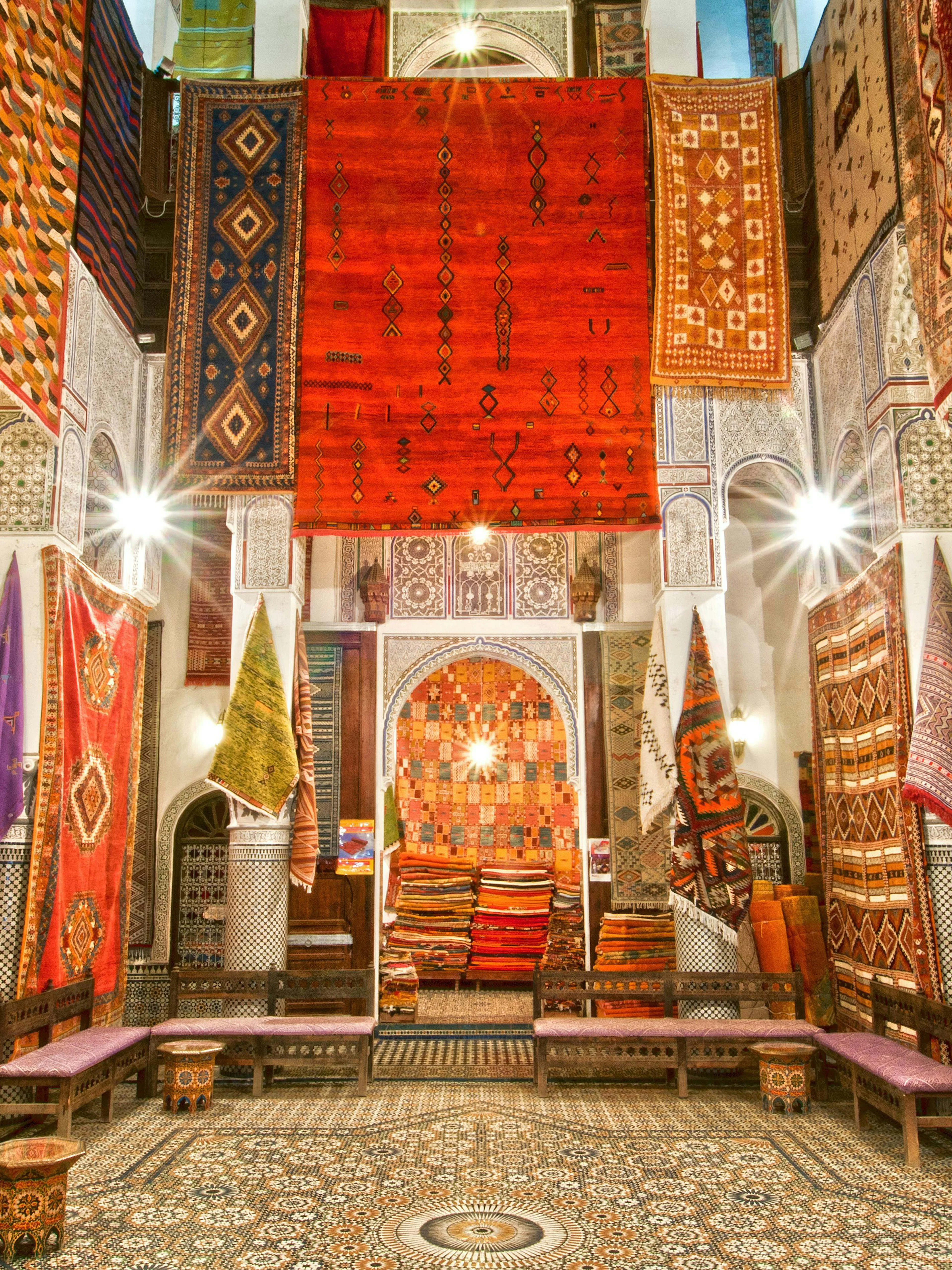 Colorful rugs displayed in a shop in Fes Old Medina, Morocco.