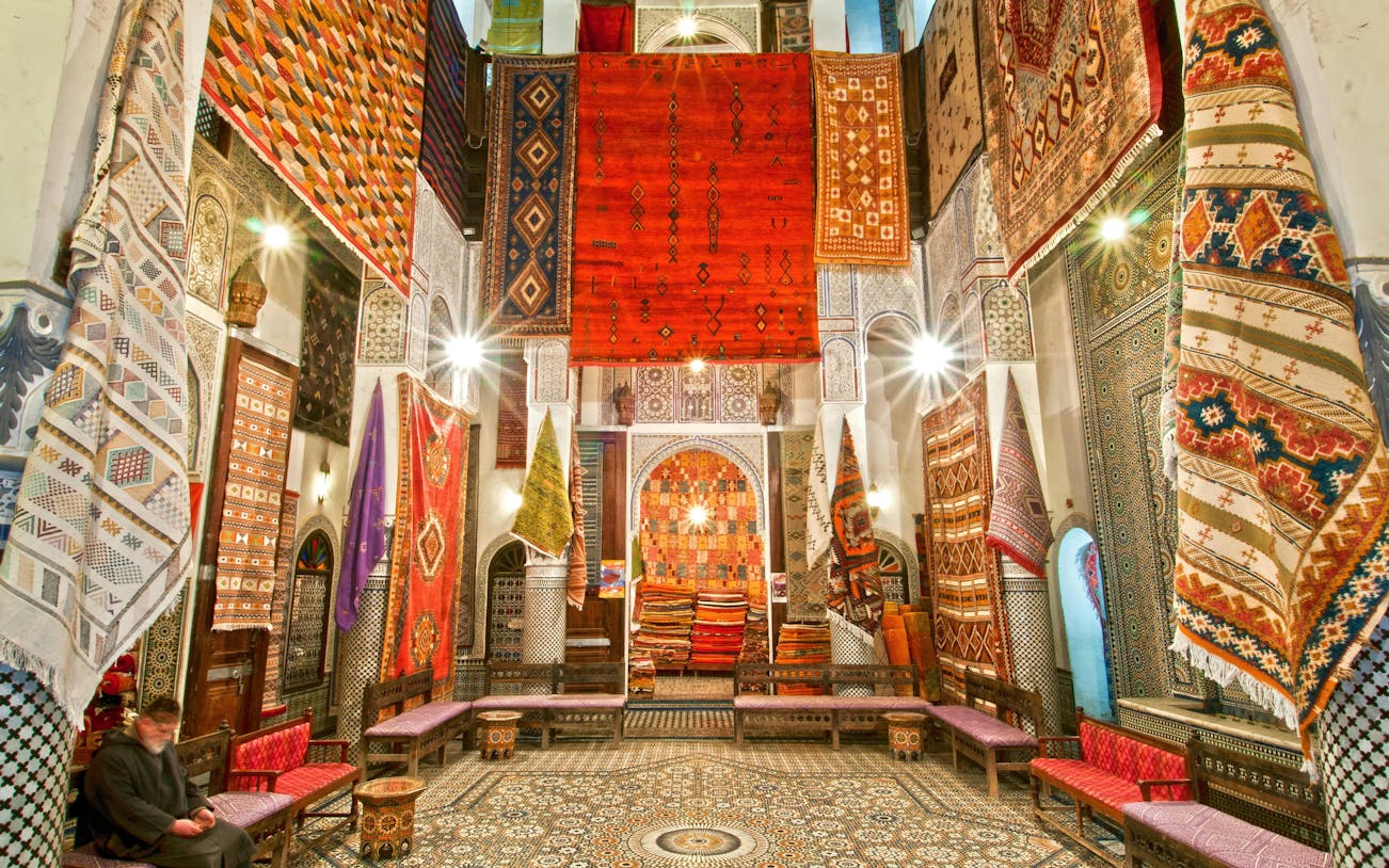 Colorful rugs displayed in a shop in Fes Old Medina, Morocco.
