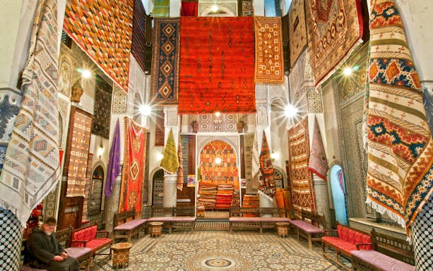 Colorful rugs displayed in a shop in Fes Old Medina, Morocco.