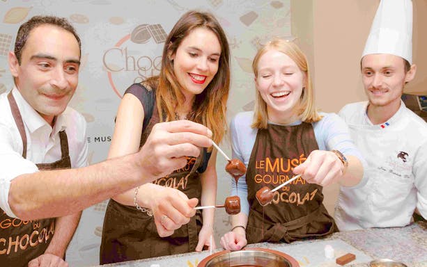 Chocolate chef guiding children in a hands-on workshop at Choco-Story Paris.
