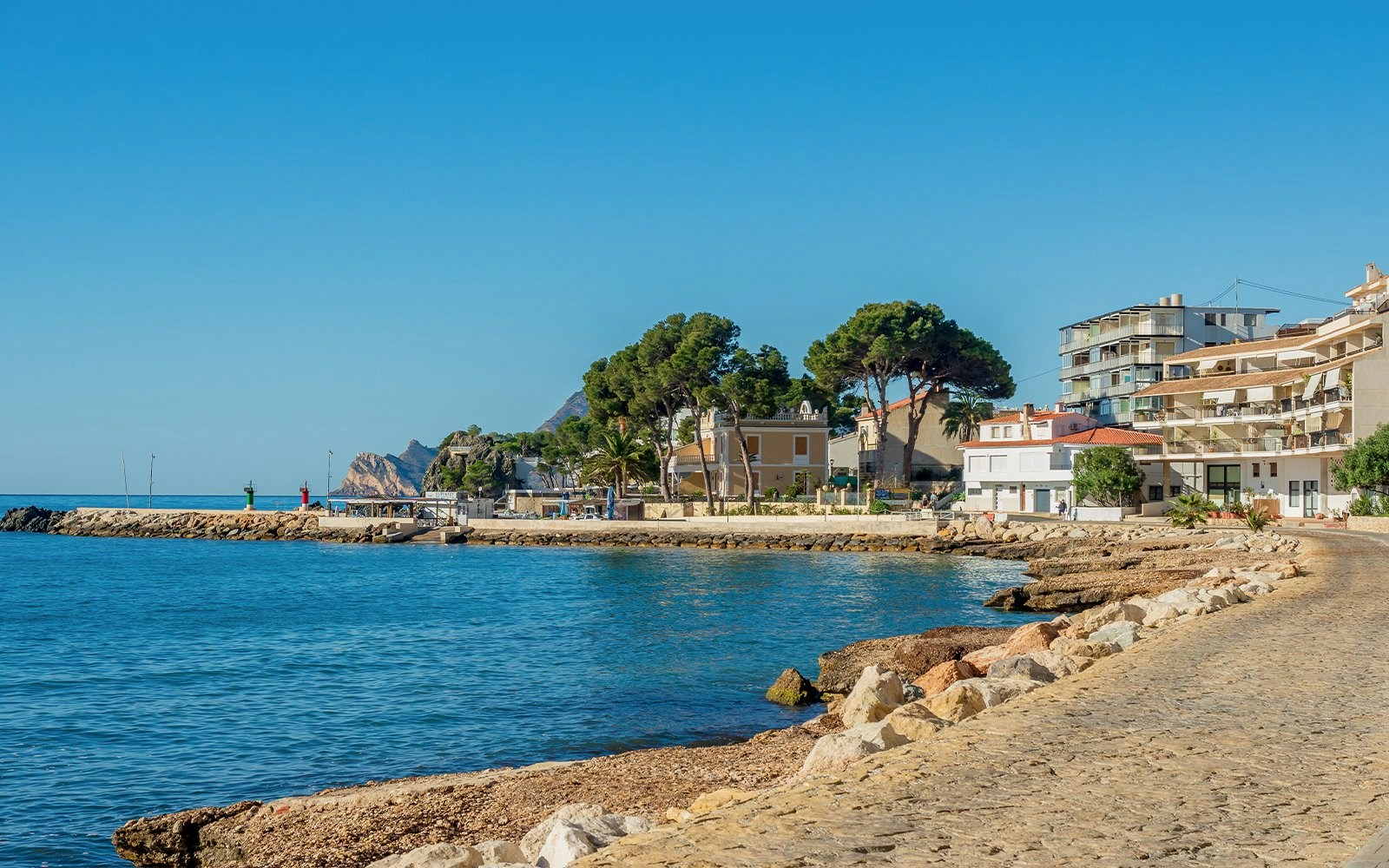 Seaside promenade at Cap Negret, Altea, with coastal buildings and clear blue water, Costa Blanca, Spain.