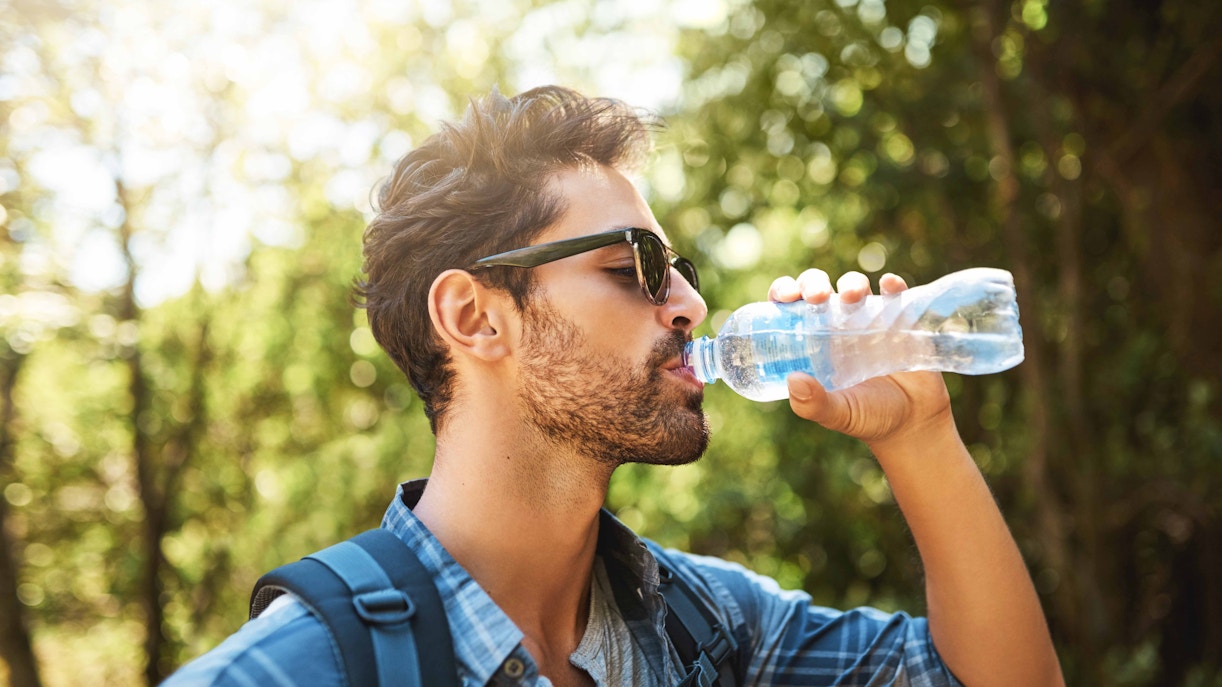 Man drinking water in a lush setting at Farm in the City, Malaysia.