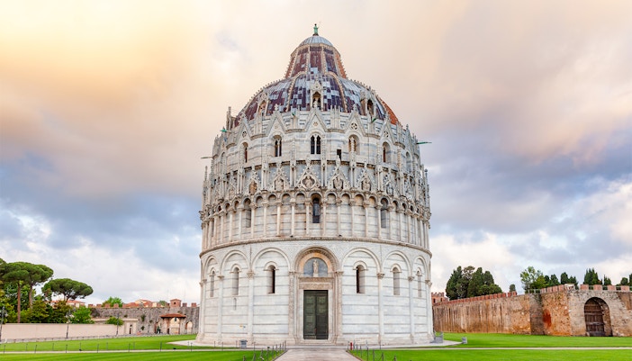 Tourists exploring the historic Pisa Baptistery, an iconic landmark in Italy offering a unique cultural experience