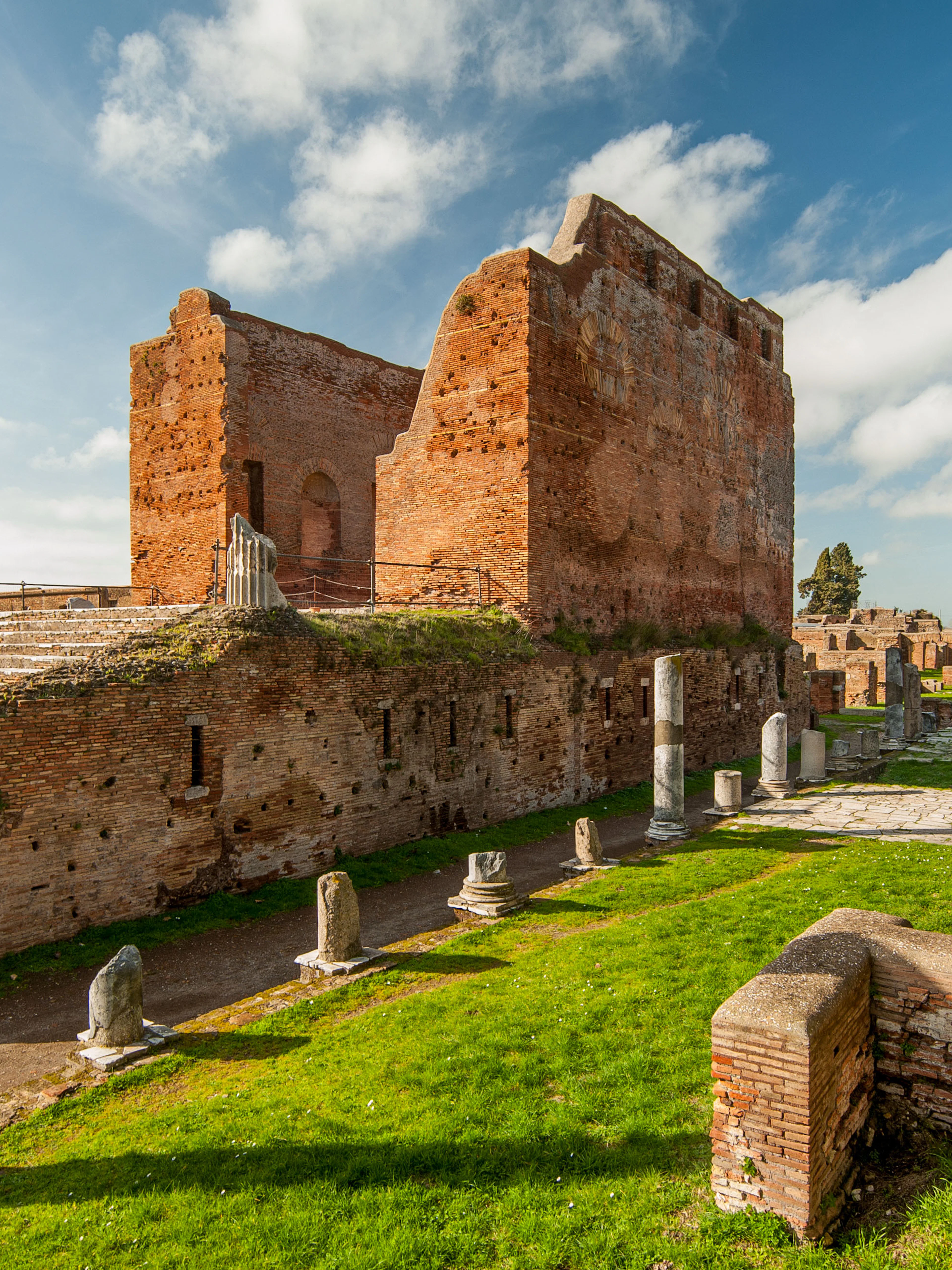Ancient ruins and columns in Ostia Antica, Italy, under a clear sky.