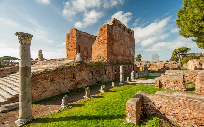 Ancient ruins and columns in Ostia Antica, Italy, under a clear sky.