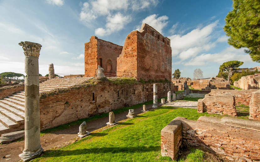 Ancient ruins and columns in Ostia Antica, Italy, under a clear sky.