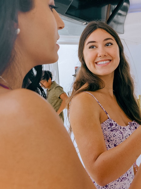 Women toasting with fruit garnished drinks on a boat.