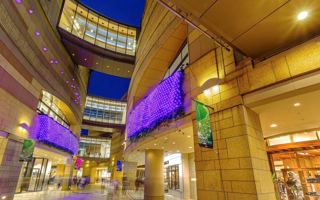 Modern architecture with illuminated purple lights at Namba Parks, Osaka.