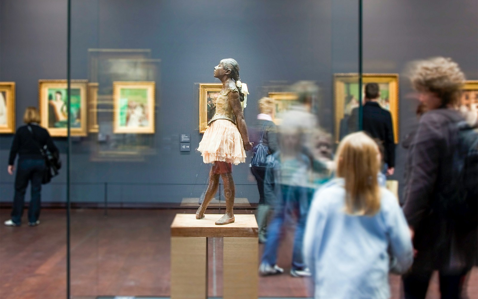 Orsay Museum interior with visitors viewing Impressionist paintings, Paris guided tour.