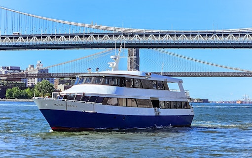 Cruise ship on New York Harbor with Brooklyn Bridge in background.