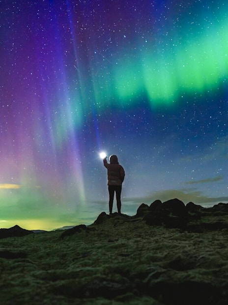 Northern lights over rocky landscape during Premium Northern Lights Super Jeep Tour.