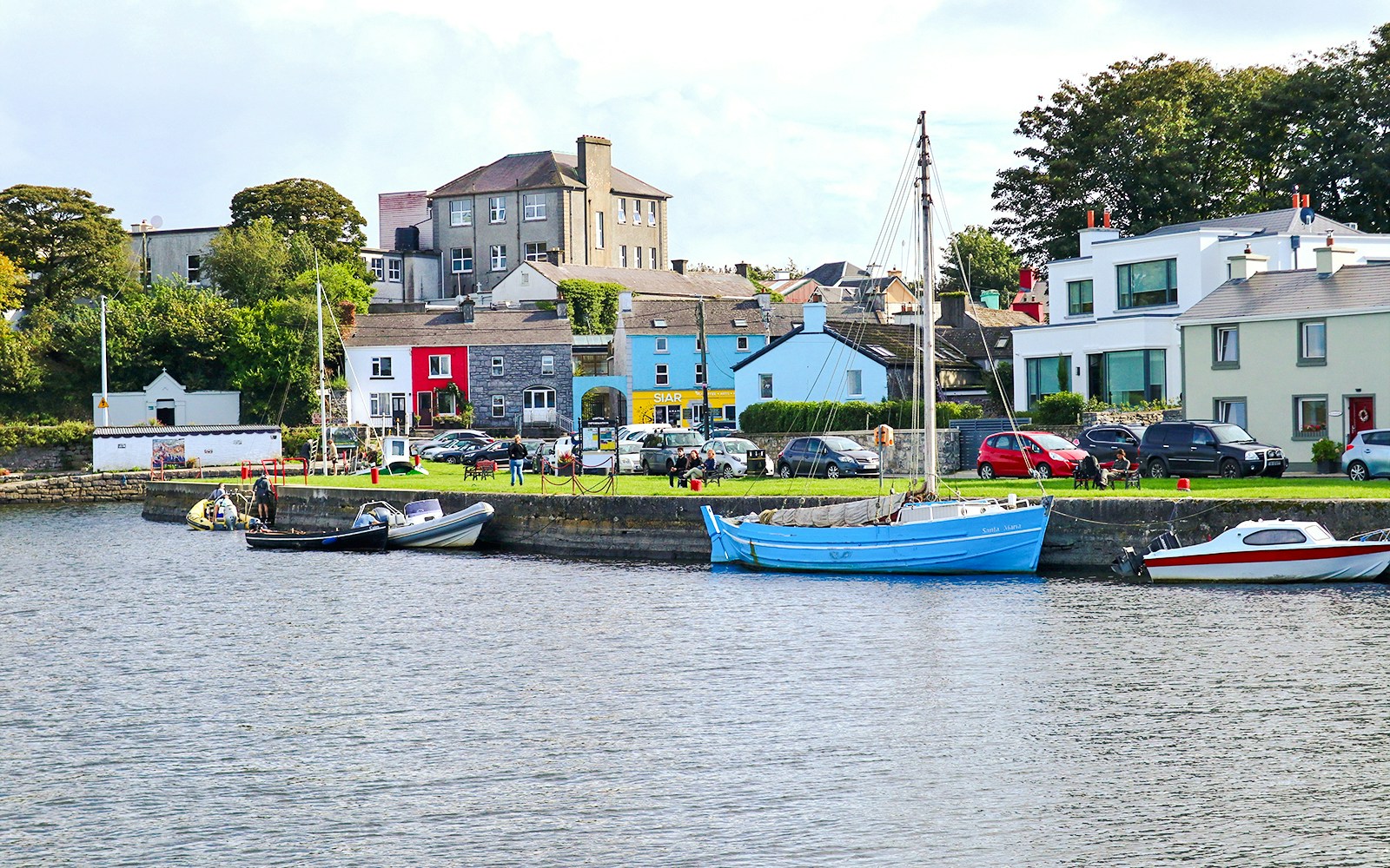 Boats docked along the colorful waterfront in Kinvara, Ireland.