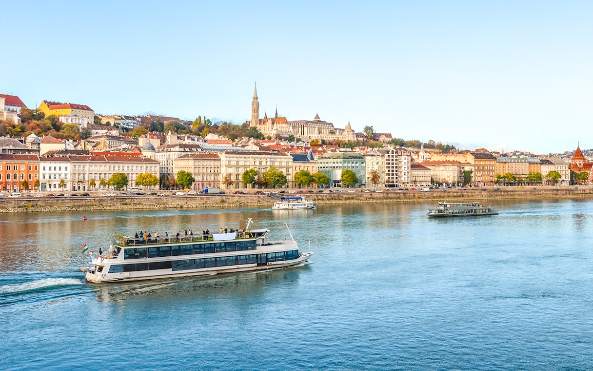 Budapest river cruise with cityscape view, including historic buildings and boats on the Danube.