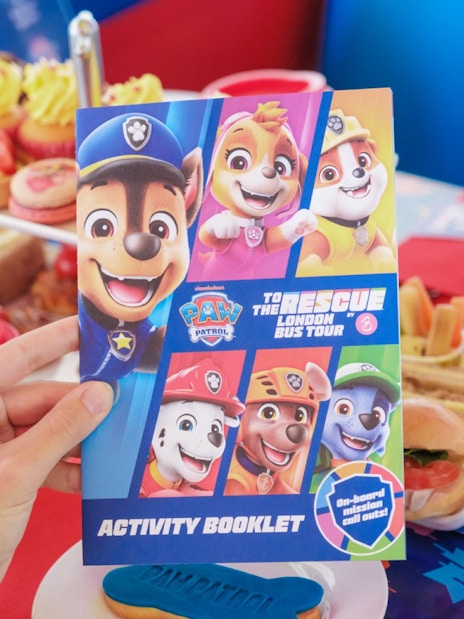Paw Patrol activity booklet on Brigit’s Afternoon Tea Bus Tour table with themed snacks.