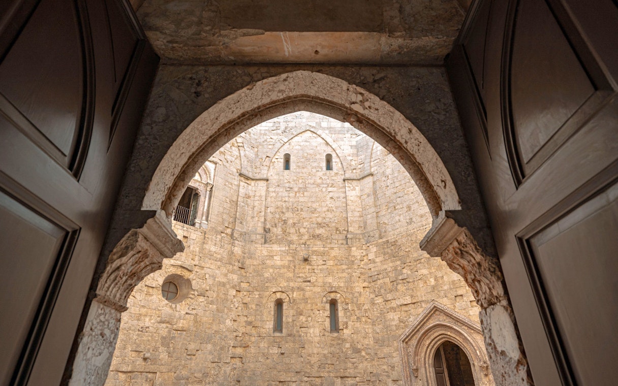Interior view of Castel del Monte's stone courtyard, showcasing medieval architecture.