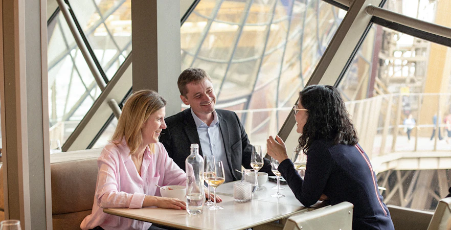 Lunch at Eiffel Tower's Madame Brasserie with view of Paris through large windows.