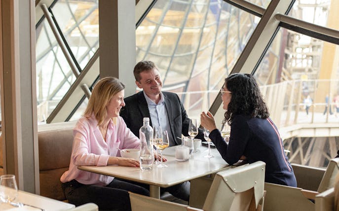 Lunch at Eiffel Tower's Madame Brasserie with view of Paris through large windows.