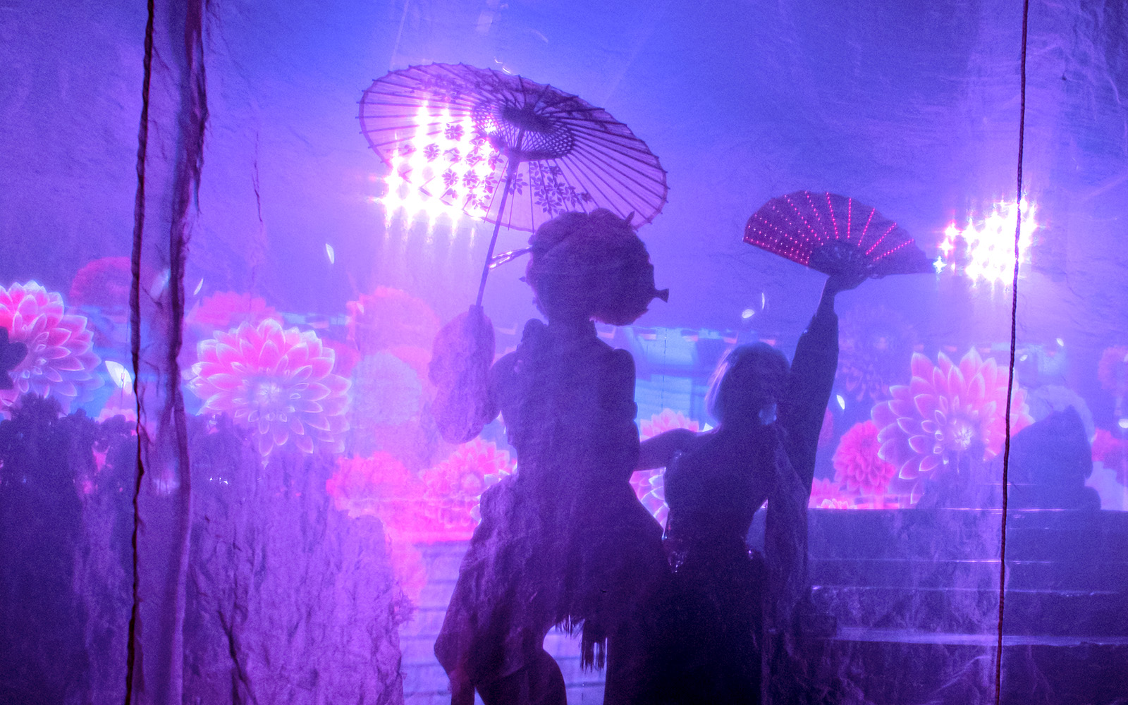 Performers with umbrellas and fans in a vibrant Samurai Restaurant Show.