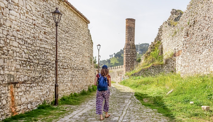 Guest walking along stone path inside Berat Castle, Albania.