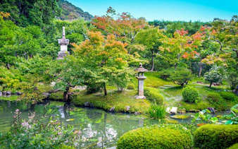 Zen garden with stone lanterns and pond at a Kyoto temple.