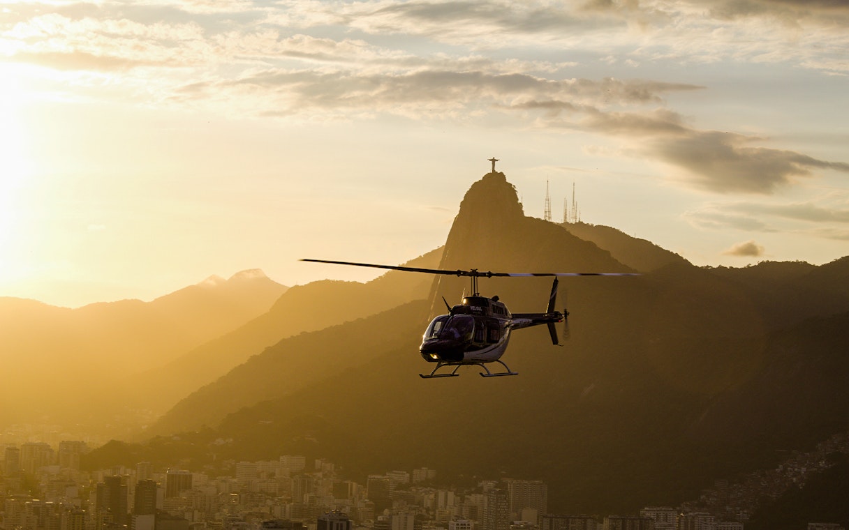 Helicopter flying at sunset with Christ the Redeemer in Rio de Janeiro.