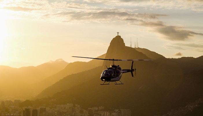 Helicopter flying at sunset with Christ the Redeemer in Rio de Janeiro.