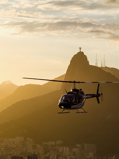 Helicopter flying at sunset with Christ the Redeemer in Rio de Janeiro.