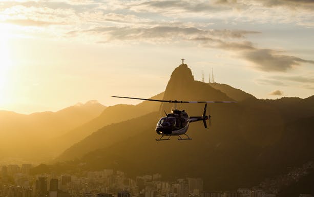 Helicopter flying at sunset with Christ the Redeemer in Rio de Janeiro.