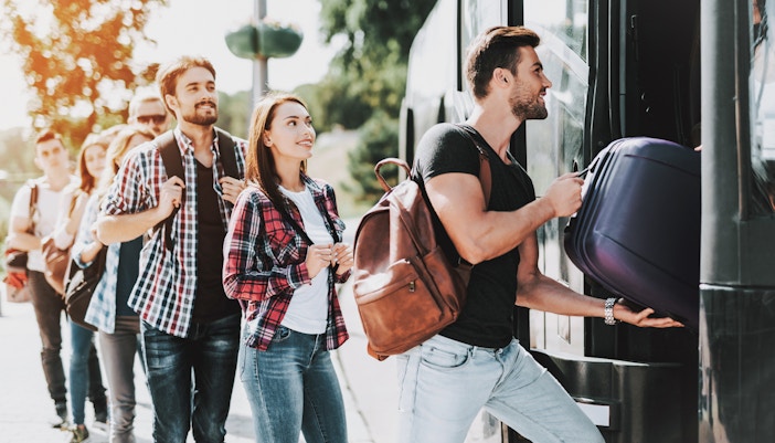 Travelers boarding shuttle bus at Shinjuku station for Tokyo Disney Resort trip.
