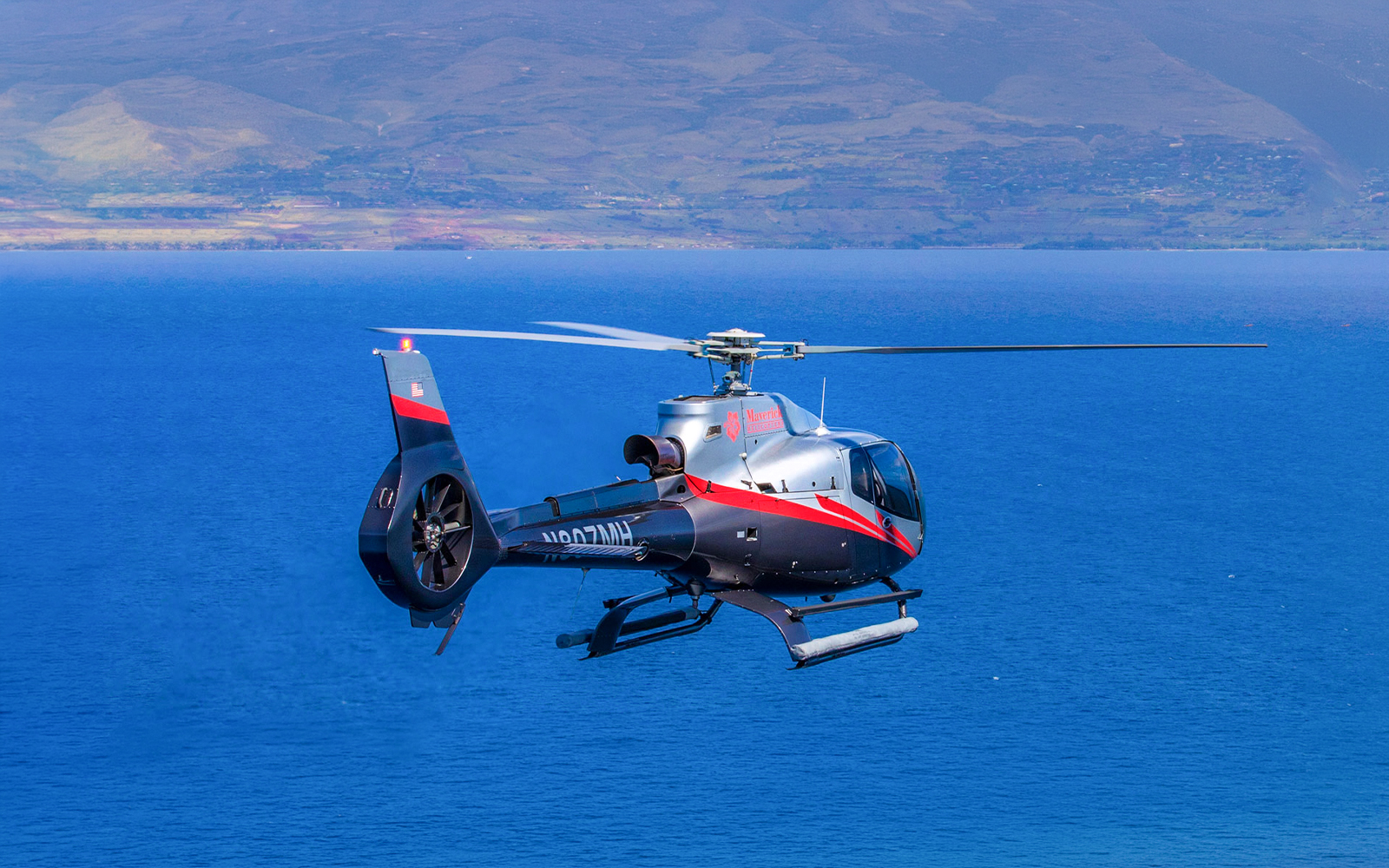 Helicopter flying over ocean near Maui, Hawaii during island tour.