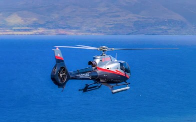 Helicopter flying over ocean near Maui, Hawaii during island tour.