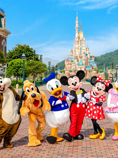 Disney characters on Main Street with castle in background, Disneyland Hong Kong.