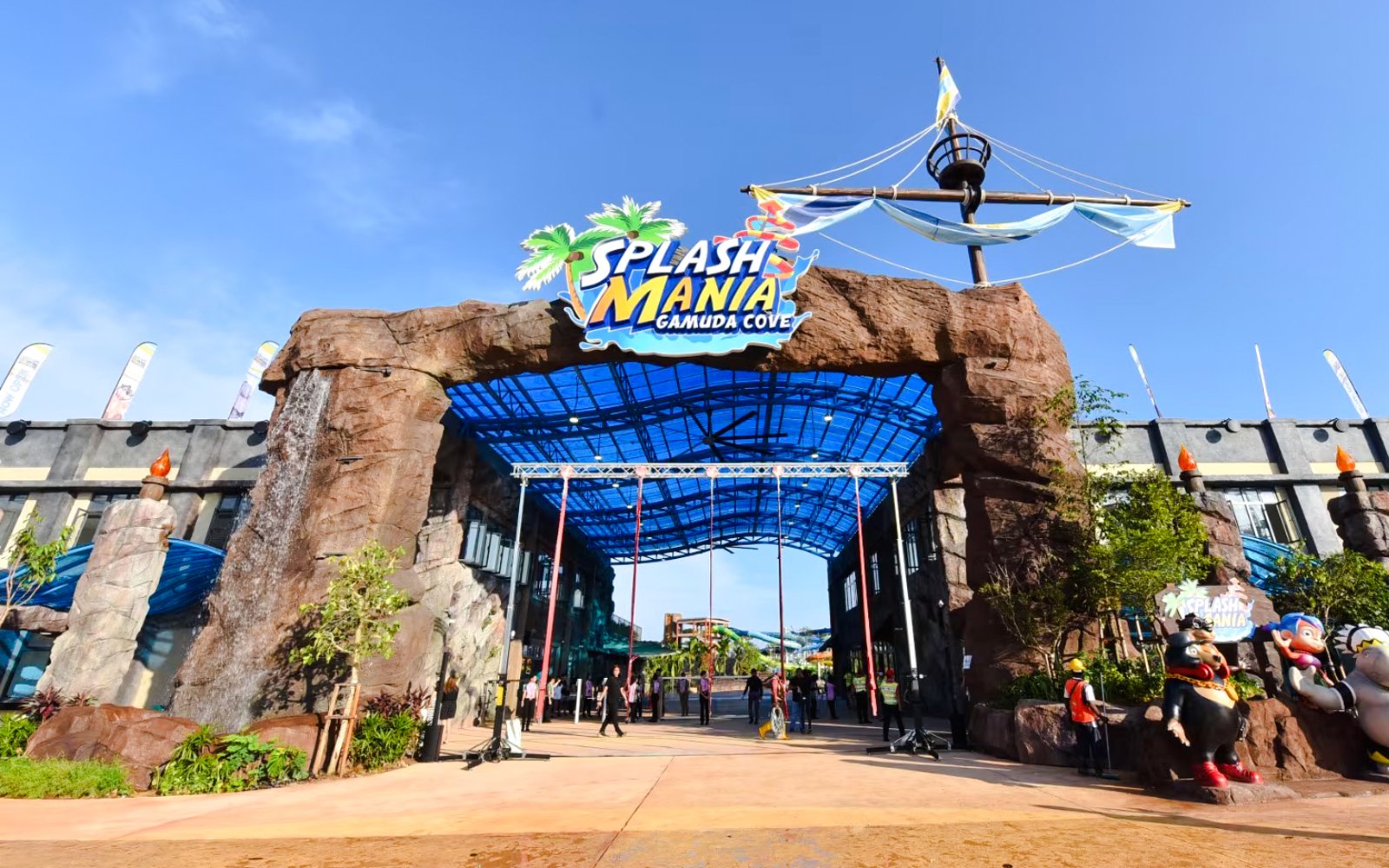 Entrance of SplashMania Waterpark with rock archway and colorful signage.