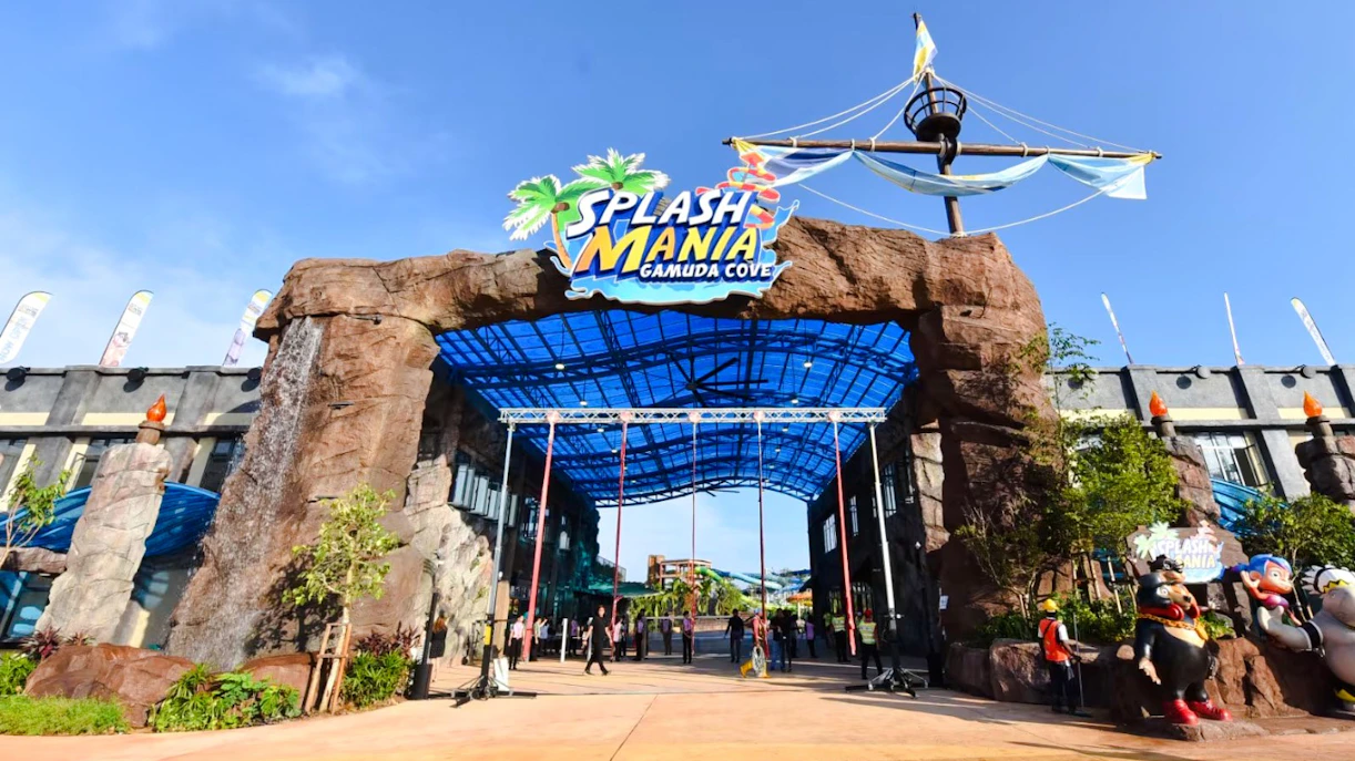 Entrance of SplashMania Waterpark with rock archway and colorful signage.
