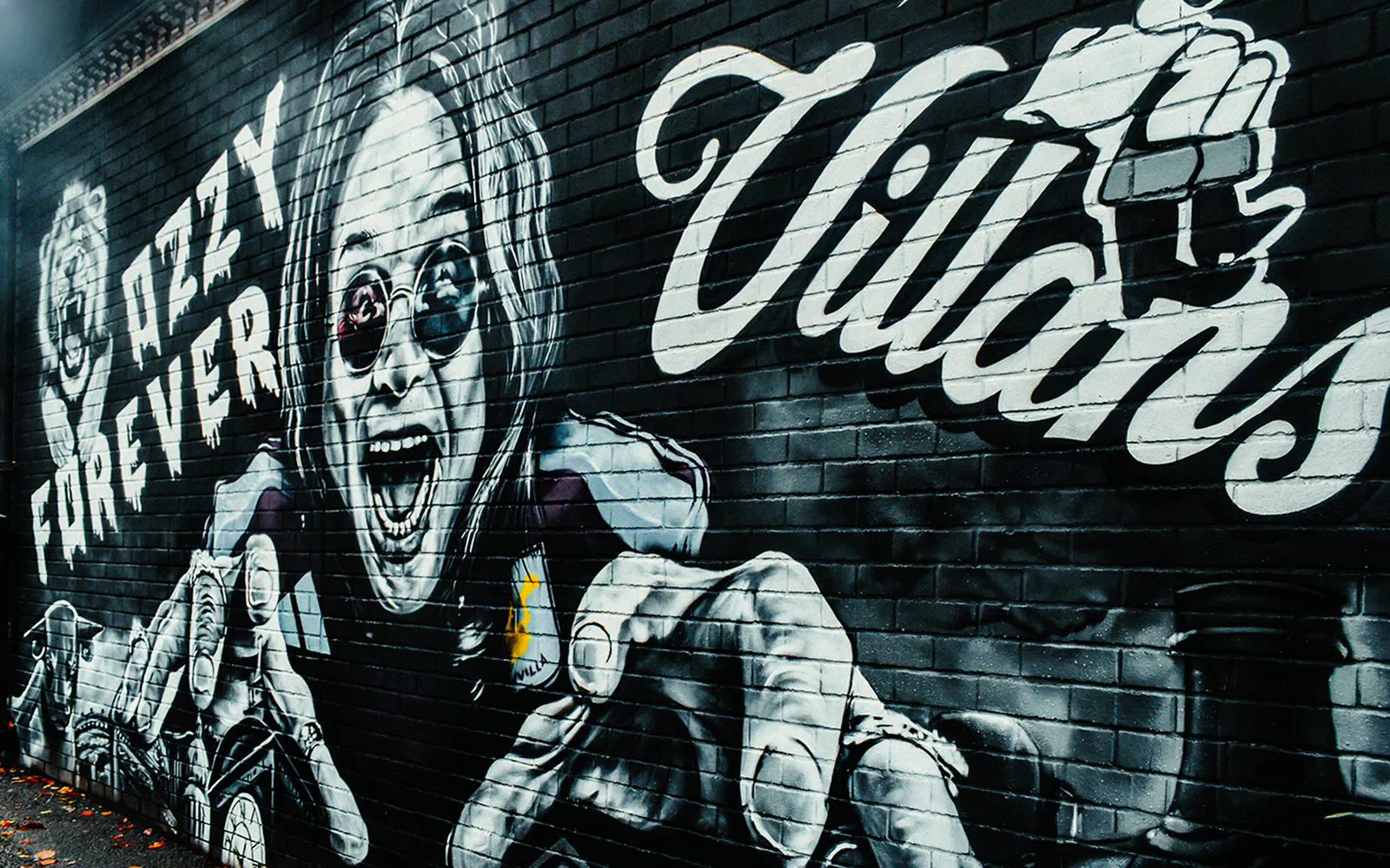 Graffiti of Ozzy Osbourne with "Ozzy Forever" text on a brick wall.