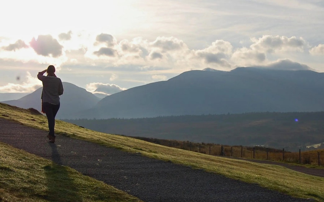 Person walking on a path with Ben Nevis in the background, Scotland.