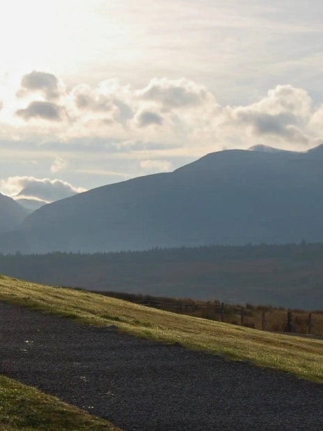 Person walking on a path with Ben Nevis in the background, Scotland.