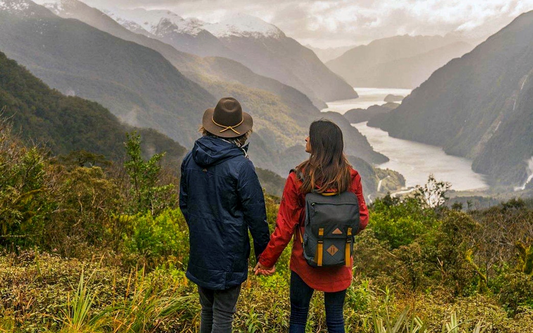 Couple overlooking Doubtful Sound fjord from Te Anau on an overnight cruise.