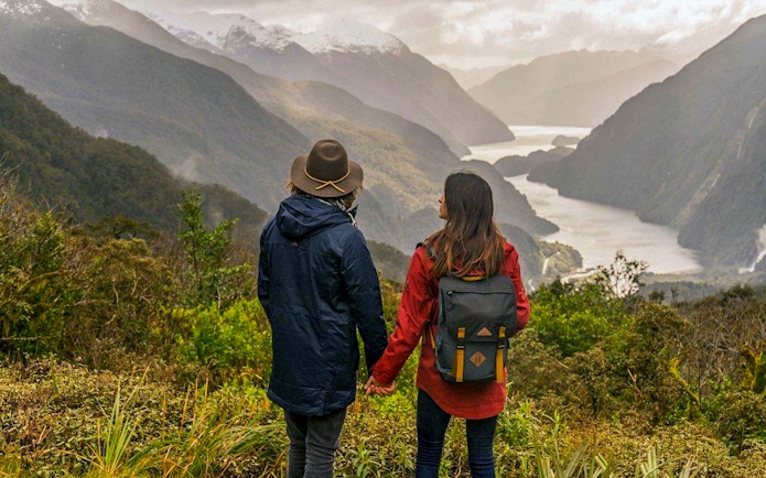 Couple overlooking Doubtful Sound fjord from Te Anau on an overnight cruise.