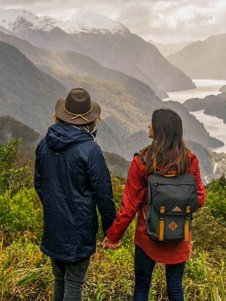 Couple overlooking Doubtful Sound fjord from Te Anau on an overnight cruise.