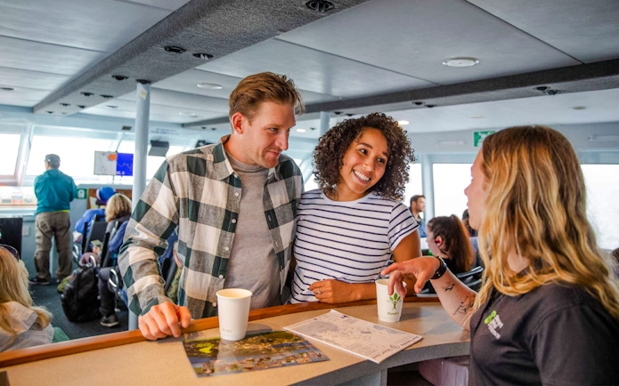 Couple talking to staff at the cafeteria on board the Stewart Island Ferry.