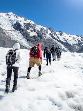 Hikers trekking on Tasman Glacier in Mount Cook National Park, New Zealand.