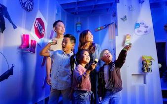 Kids using flashlights to explore interactive exhibits at SparkLab, Queensland Museum.